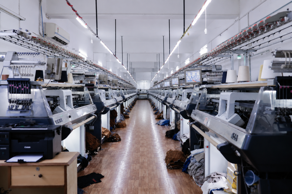 A  view inside a high-end apparel manufacturing partner facility utilizing advanced computerized flat knit machinery.